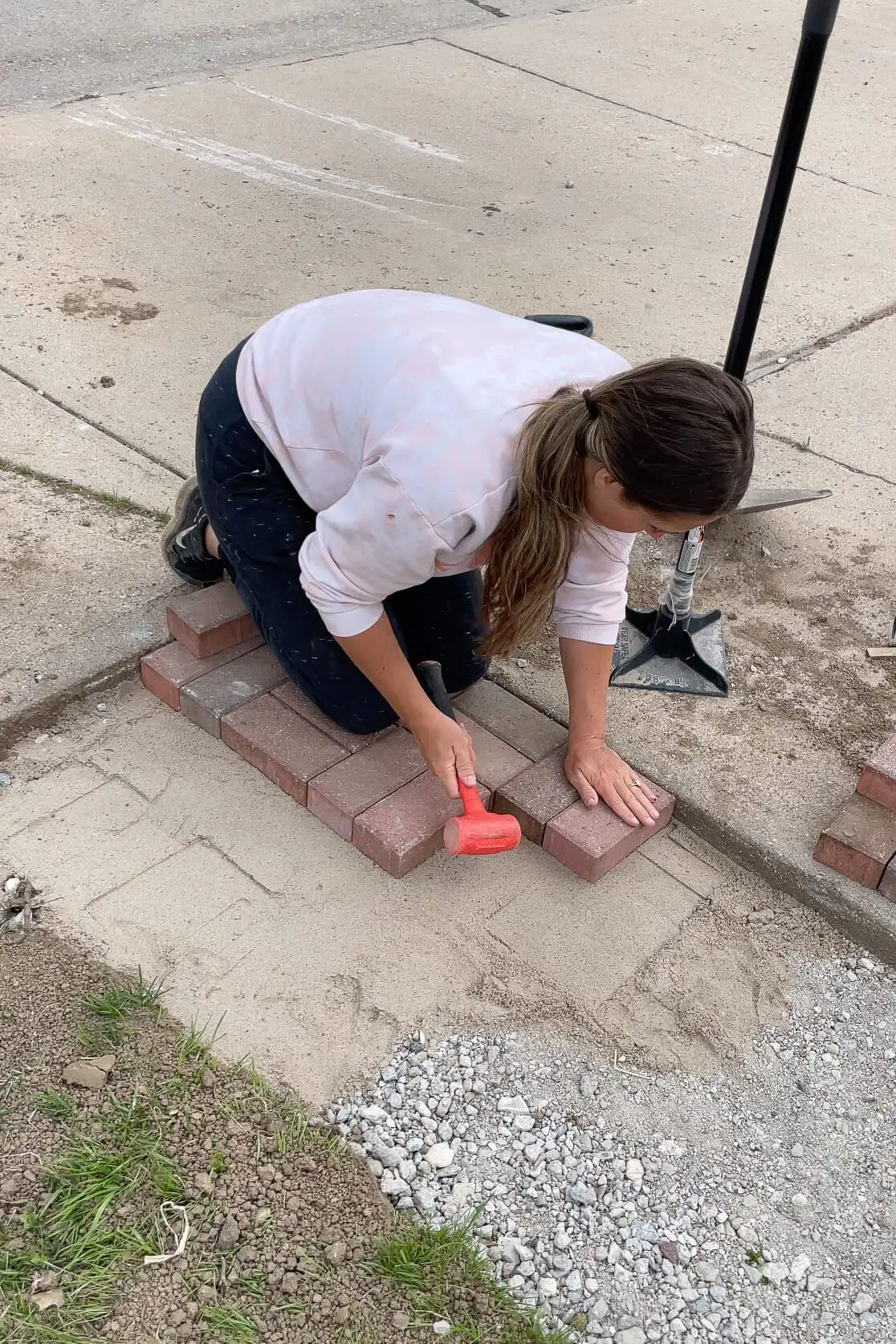 Laying pavers for DIY paver driveway extension.